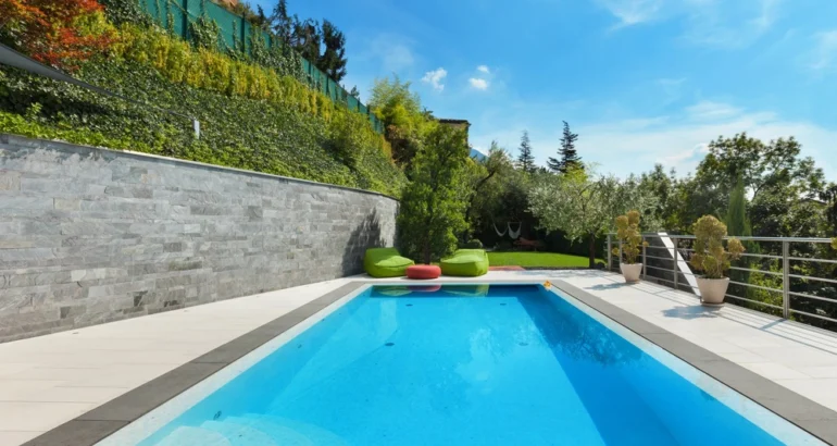 Piscine en béton dans un jardin avec de la végétation autour